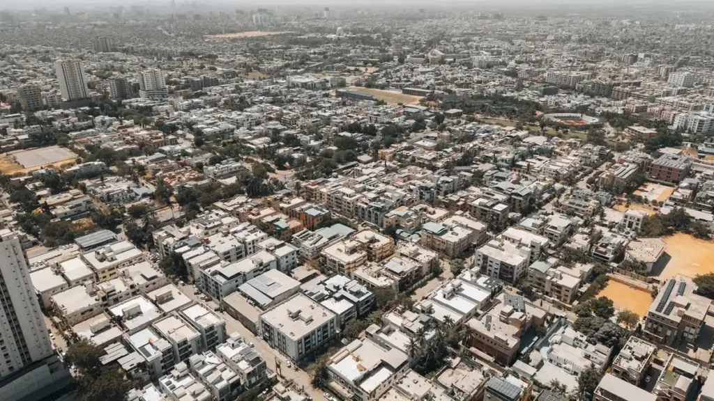 Aerial view of dense low-rise residential blocks and streets across Karachi under a hazy sky