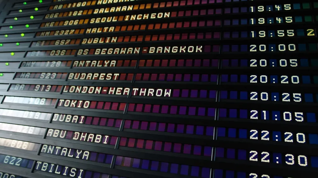 Airport departure board listing evening flights to destinations including Dubai, Abu Dhabi and London Heathrow