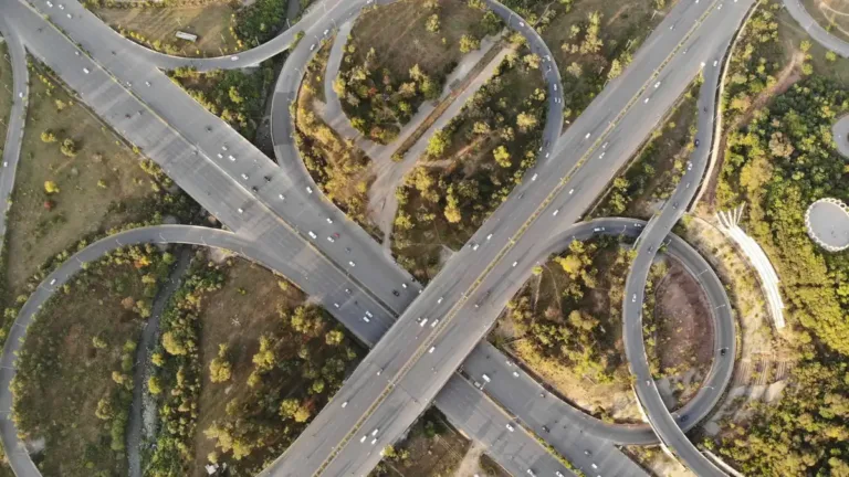 Aerial view of a multi-level highway interchange with looping ramps set among trees and green verges