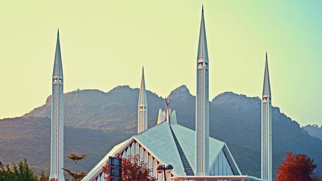 Faisal Mosque in Islamabad with its four tall minarets and tent-like roof against the Margalla Hills