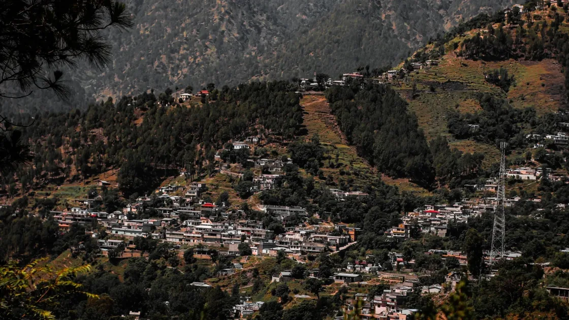 Aerial view of Murree town spread across forested green hills in the Punjab highlands of northern Pakistan