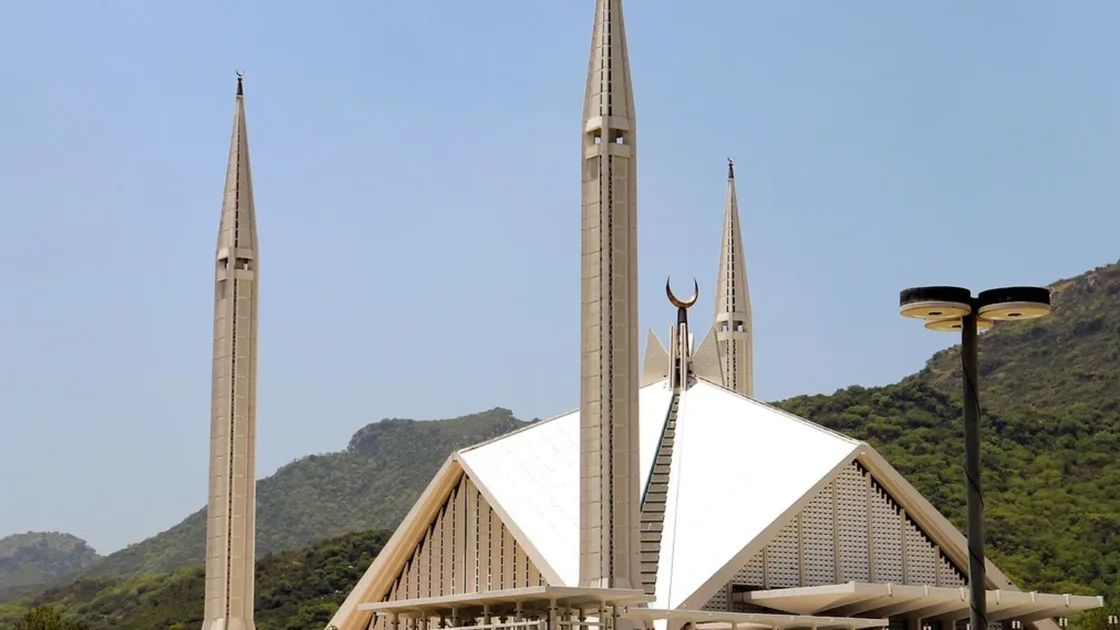 Faisal Mosque in Islamabad with its tent-shaped hall and four minarets against the green Margalla Hills